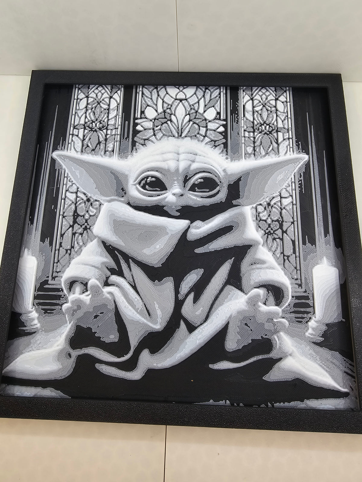 3D printed grayscale Baby Yoda artwork in a black frame, featuring a stained glass background.