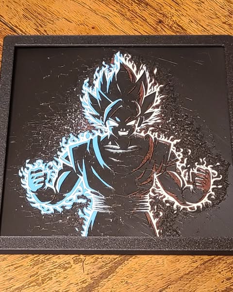 3D printed Goku Hue wall art featuring a black silhouette with blue and white glowing aura effects.