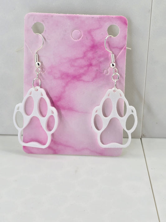 3D printed white hollow wolf paw print dangle earrings with silver-plated hooks on a pink card.