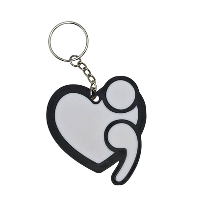 Heart-shaped keychain with a white semicolon symbol on a white background