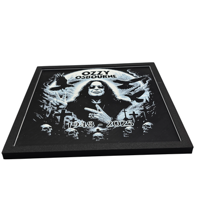 Framed memorial painting for Ozzy Osbourne with crows, skulls, and cross symbols and birth and death years on a black background.