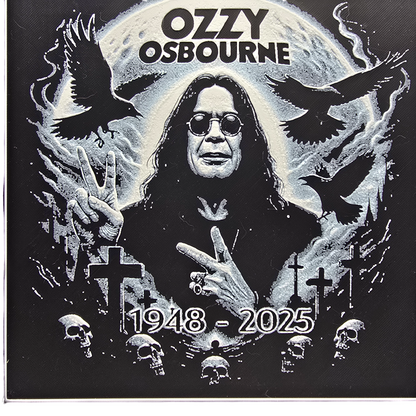 Framed memorial painting for Ozzy Osbourne with crows, skulls, and cross symbols and birth and death years on a black background.