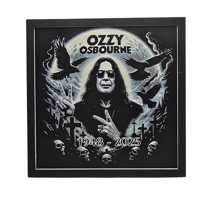 Framed memorial painting for Ozzy Osbourne with crows, skulls, and cross symbols and birth and death years on a black background.