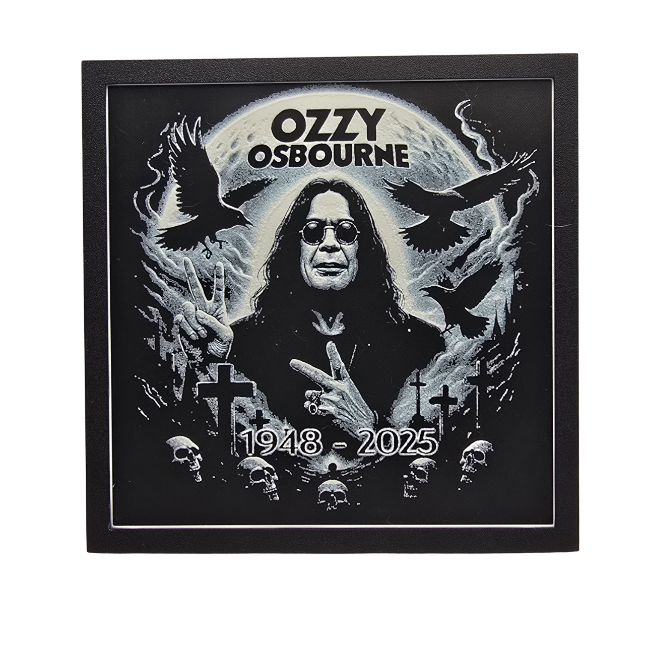 Framed memorial painting for Ozzy Osbourne with crows, skulls, and cross symbols and birth and death years on a black background.