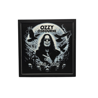 Framed memorial painting for Ozzy Osbourne with crows, skulls, and cross symbols and birth and death years on a black background.
