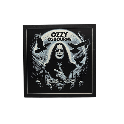 Framed memorial painting for Ozzy Osbourne with crows, skulls, and cross symbols and birth and death years on a black background.