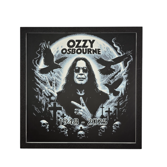 Framed memorial painting for Ozzy Osbourne with crows, skulls, and cross symbols and birth and death years on a black background.