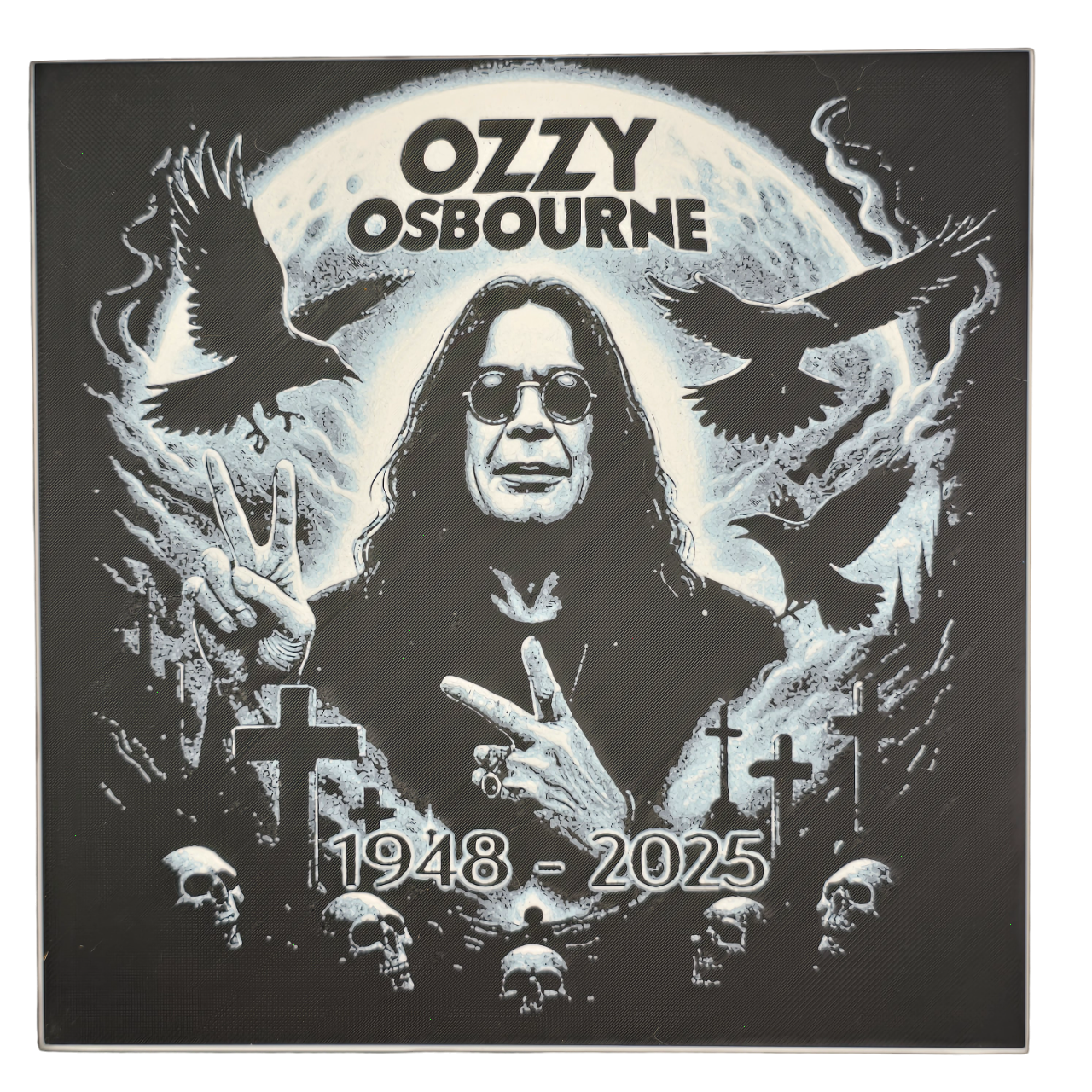 Framed memorial painting for Ozzy Osbourne with crows, skulls, and cross symbols and birth and death years on a black background.