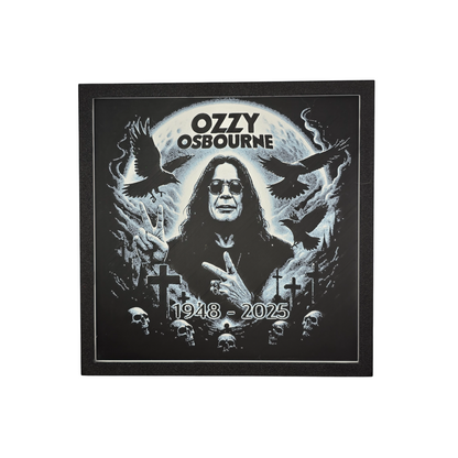 Framed memorial painting for Ozzy Osbourne with crows, skulls, and cross symbols and birth and death years on a black background.