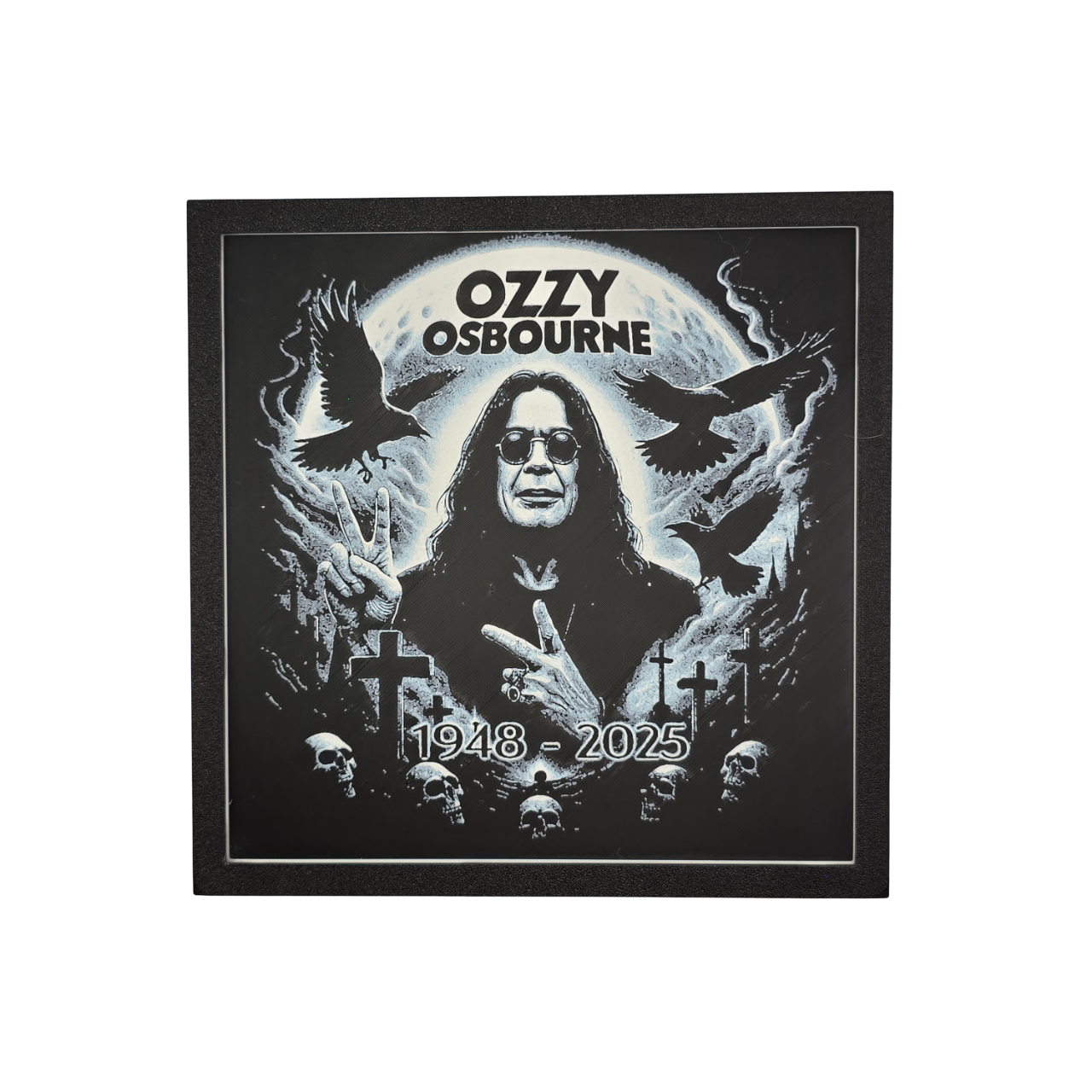 Framed memorial painting for Ozzy Osbourne with crows, skulls, and cross symbols and birth and death years on a black background.