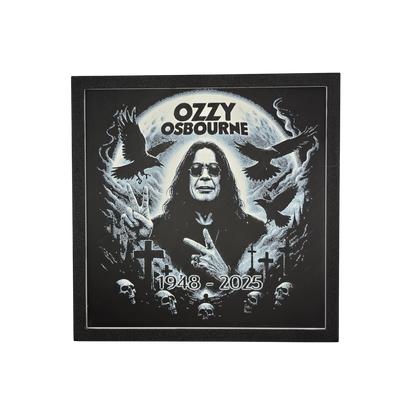 Framed memorial painting for Ozzy Osbourne with crows, skulls, and cross symbols and birth and death years on a black background.