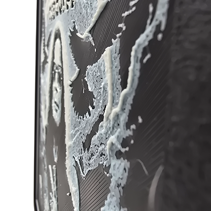 Close up side view of framed memorial painting for Ozzy Osbourne with crows, skulls, and cross symbols and birth and death years on a black background.