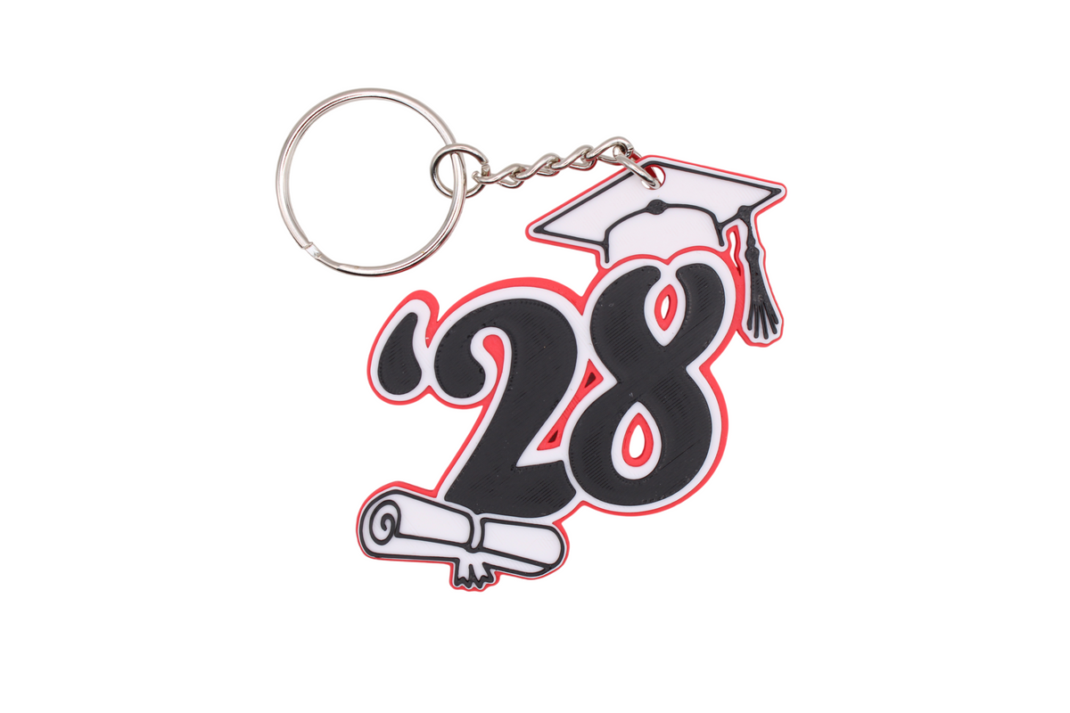 3D printed '28 graduation keychain in red, white, and black with a cap and diploma.