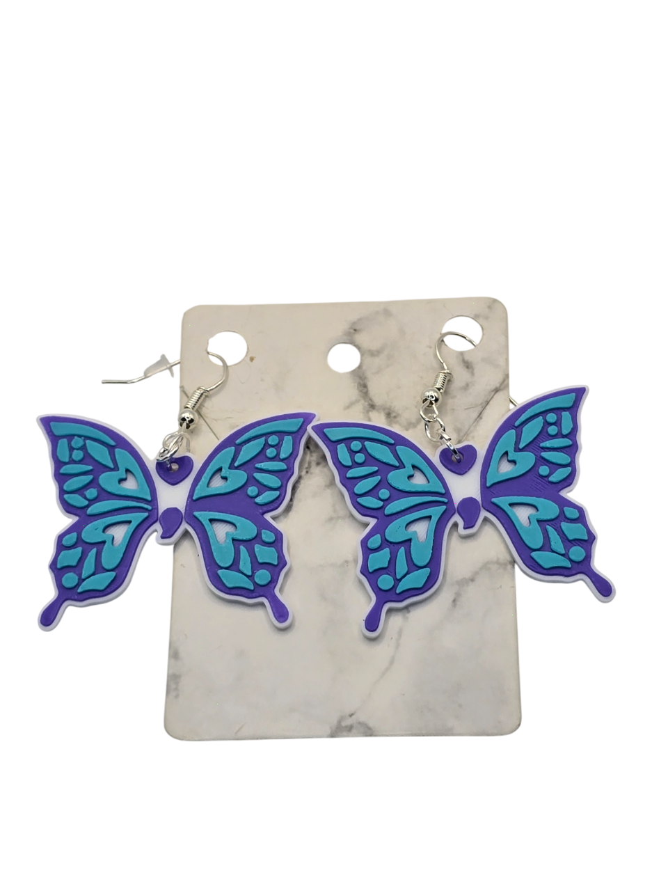 Butterfly-shaped earrings on a marble background