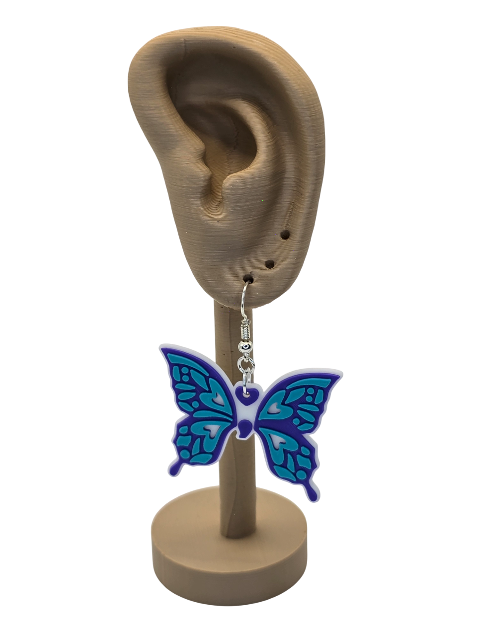 Butterfly earring on a display stand with an ear model.
