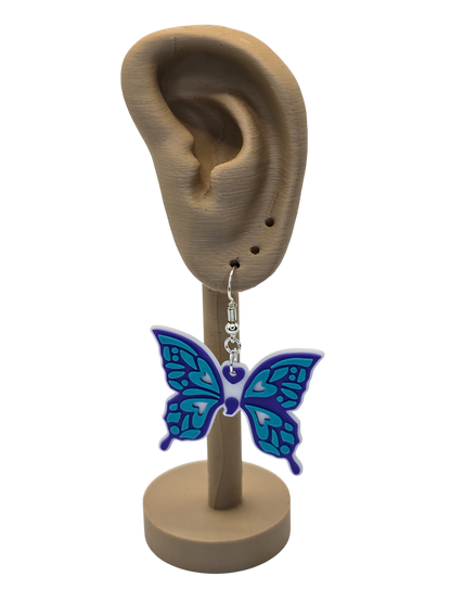Butterfly earring on a display stand with an ear model.