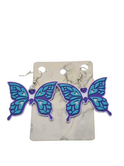 Butterfly-shaped earrings on a marble card with a white background