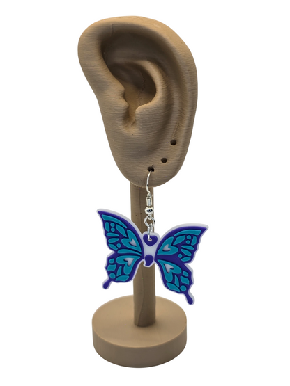 Butterfly earring on a display stand with an ear model.