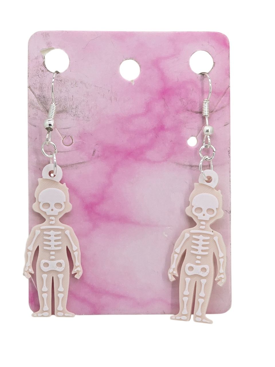 Beige skeleton earrings with white layered bone details displayed on a pink marbled backing card.