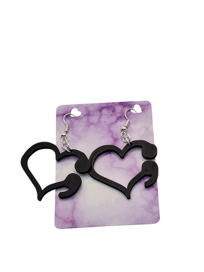 Black heart-shaped earrings on a purple and white marbled card