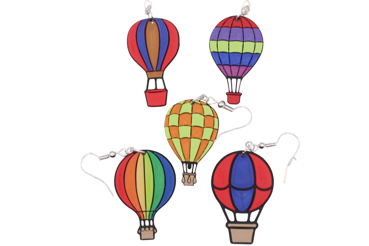 Five pairs of colorful 3D printed hot air balloon earrings in various patterns and stripes.