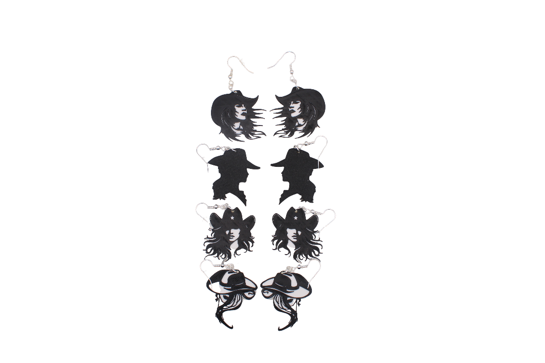 Four pairs of black and white 3D printed cowgirl silhouette earrings in various stylized designs.