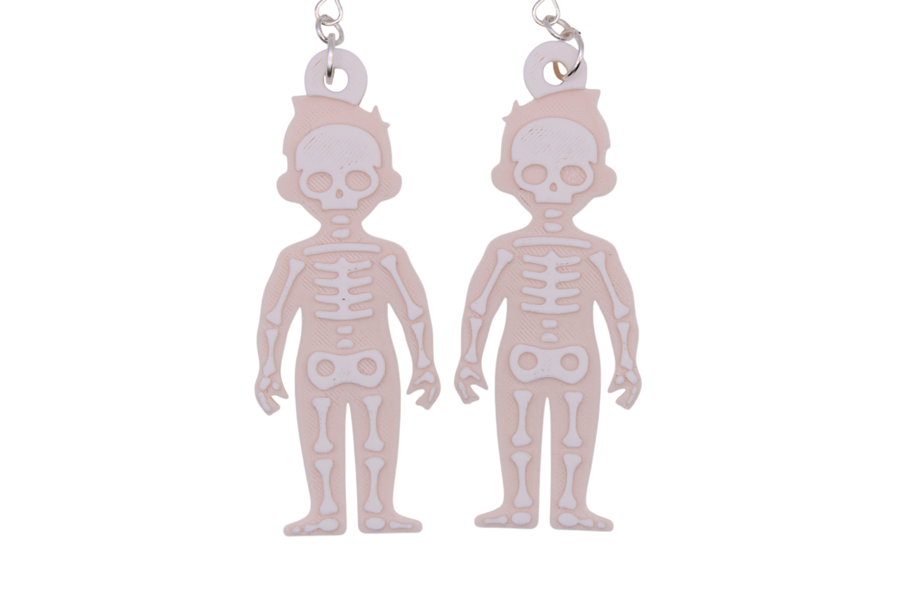 Two large beige skeleton earrings with white layered bone details, shown side by side on metal hooks.