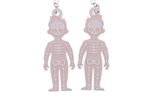 Two large beige skeleton earrings with white layered bone details, shown side by side on metal hooks.