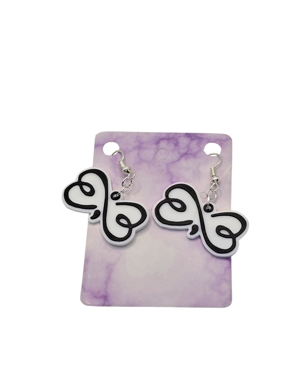 Pair of black and white infinity-shaped earrings on a purple and white marbled card.