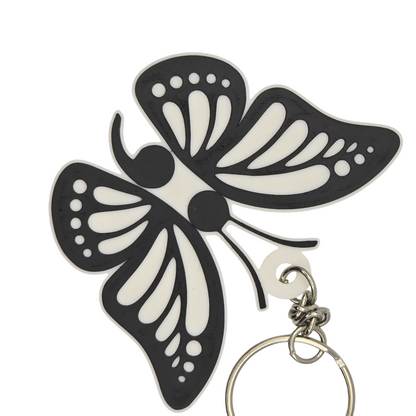 Butterfly-shaped keychain with black and white design on a white background