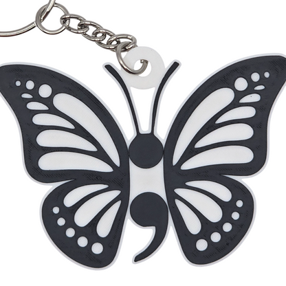 Butterfly-shaped keychain with black and white design on a white background