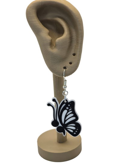 Butterfly-shaped earring on a 3d printed mannequin ear with a white background