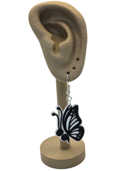 Butterfly-shaped earring on a mannequin ear with a white background