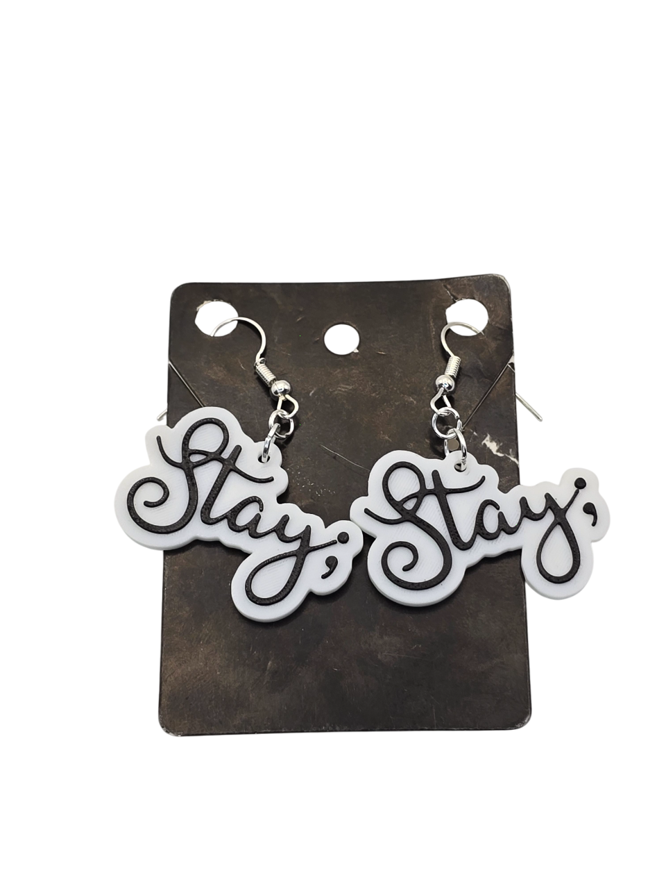 Pair of 'Stay ;' earrings on a black card with a white background