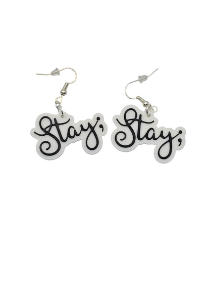 Pair of earrings with 'Stay ;' text on a white background