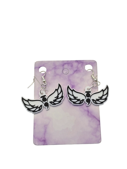 Pair of wing-shaped with a semicolon earrings on a purple and white marbled card