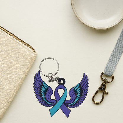 Keychain with teal and purple wings and a teal and purple ribbon with a pouch and lanyard.