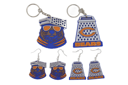 Full 3D printed Chicago Bears collection lineup — blue bear head keychain with orange sunglasses and cheese grater keychain with orange C logo on top, four cheese grater earrings below, all in Bears blue, orange, and white.