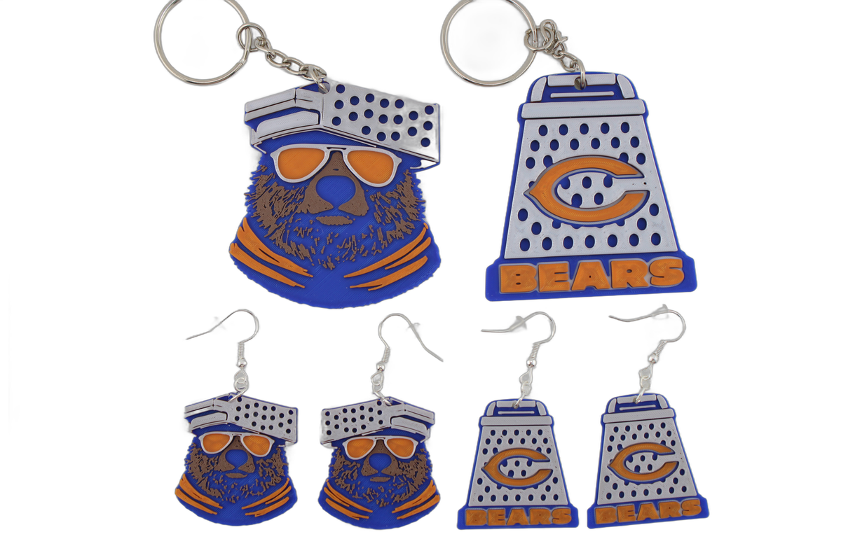 Complete 3D printed Chicago Bears set — bear head keychain and cheese grater keychain above, four matching cheese grater earrings arranged below on white.