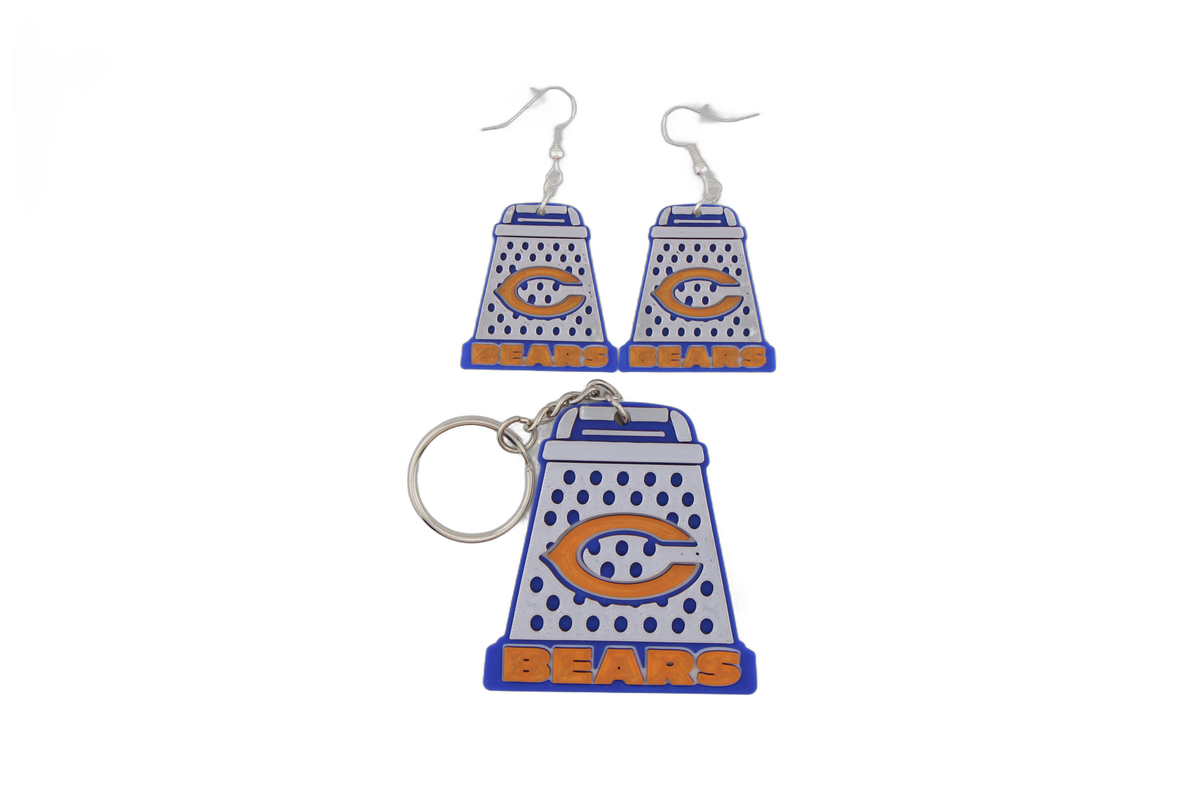 3D printed Chicago Bears cheese grater keychain with a matching pair of cheese grater earrings — blue and white with orange C logo and BEARS text.