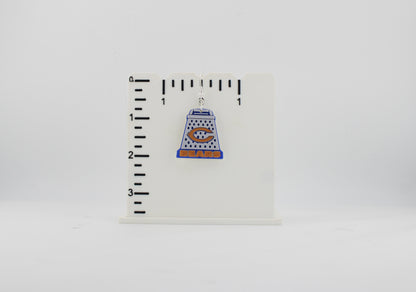3D printed Chicago Bears cheese grater earring next to a ruler showing approx. 1.25 inch height for size reference.