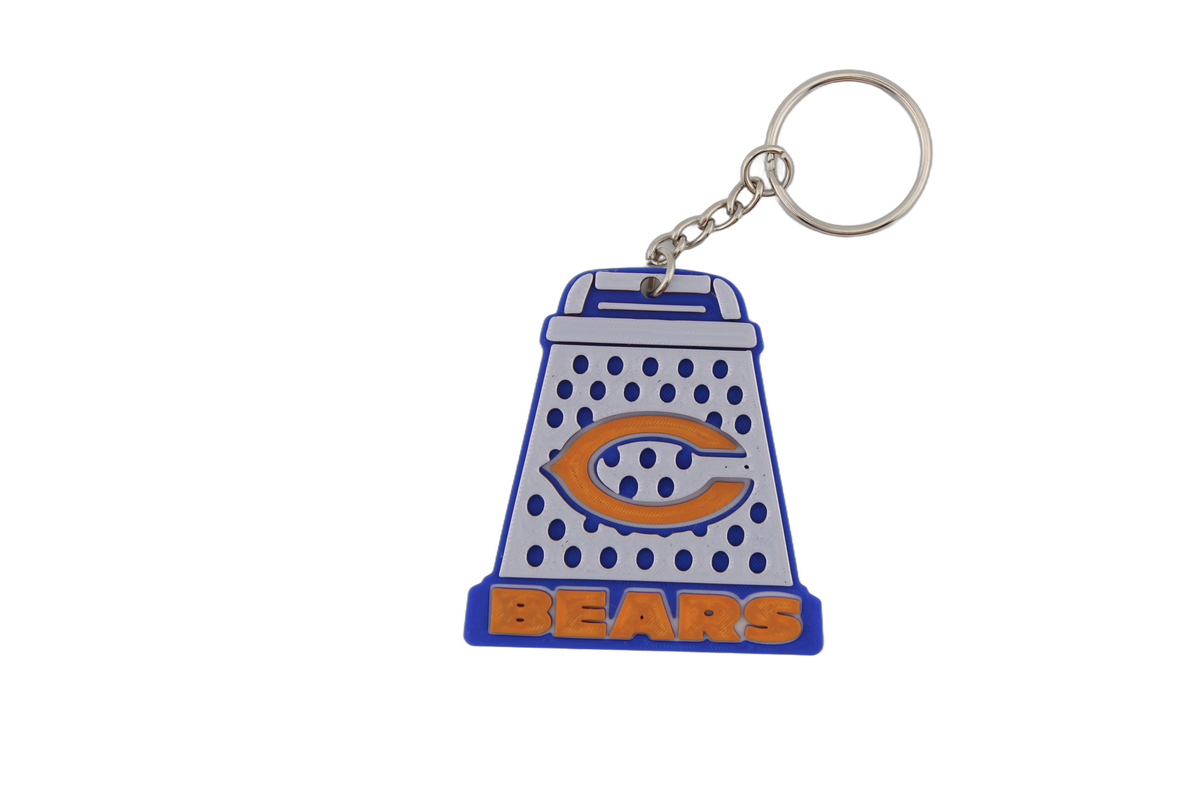 Single 3D printed Chicago Bears cheese grater keychain featuring the orange C logo and BEARS lettering in team blue, orange, and white with metal split ring.