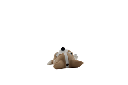 Top-down close-up of a tan and white 3D printed corgi figurine's head while it lies on its back, showing its white forehead stripe, pointed ears and black nose — from Erratically Eccentric Creations.