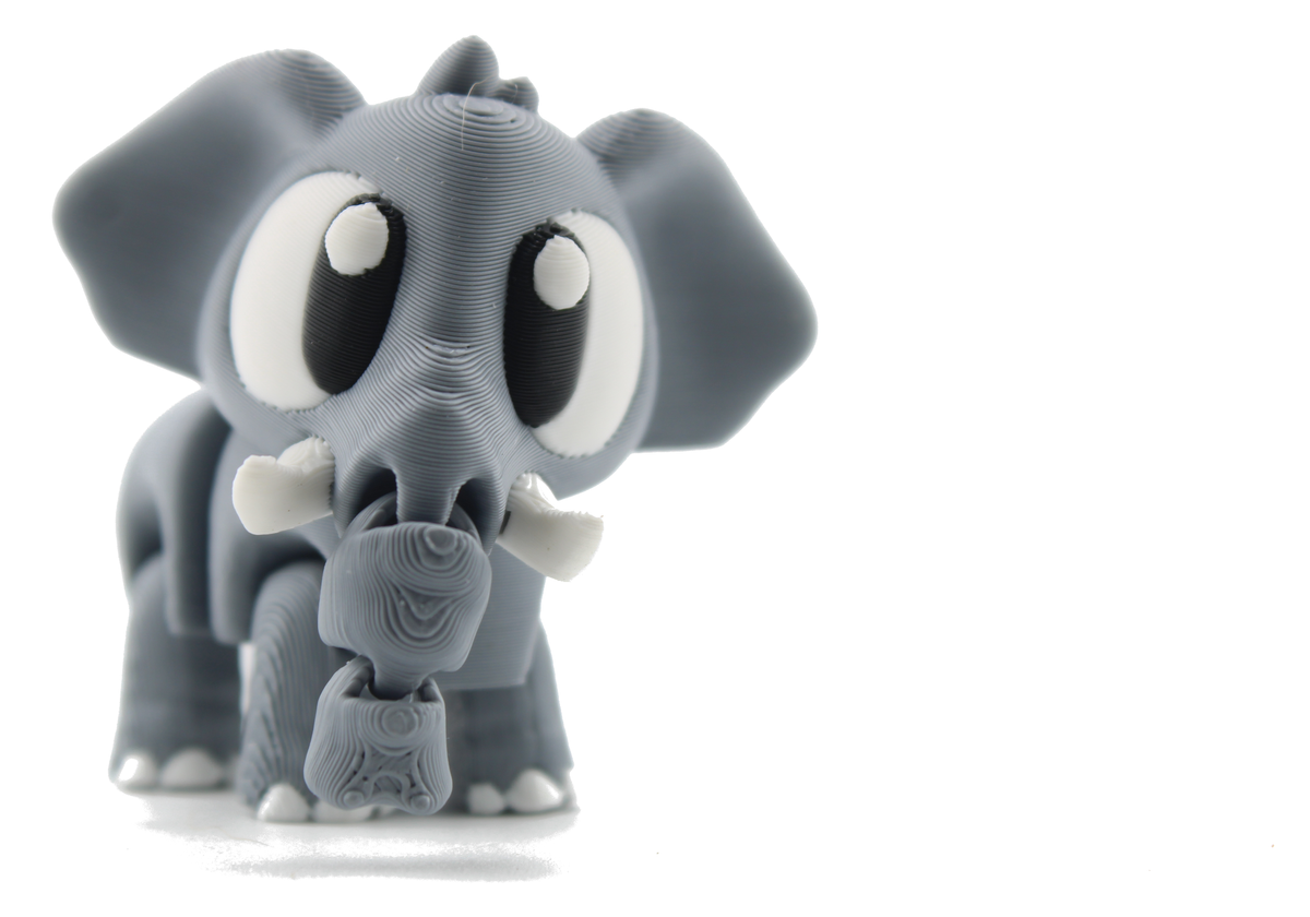 Front view of the 3D printed flexi baby elephant standing tall, gray body, wide ears, white tusks and trunk hanging down