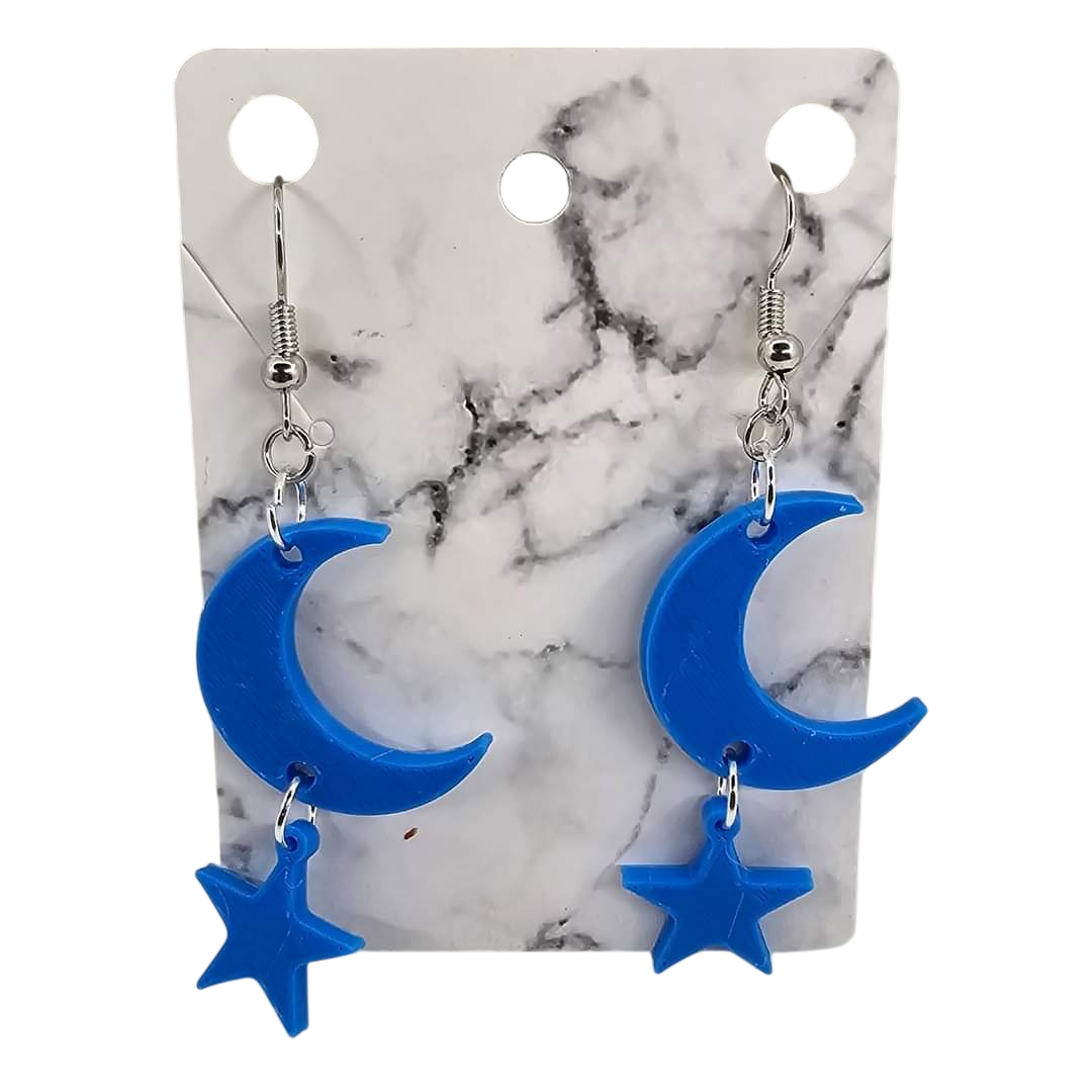 Blue 3D printed moon and star earrings on a marble-patterned display card.
