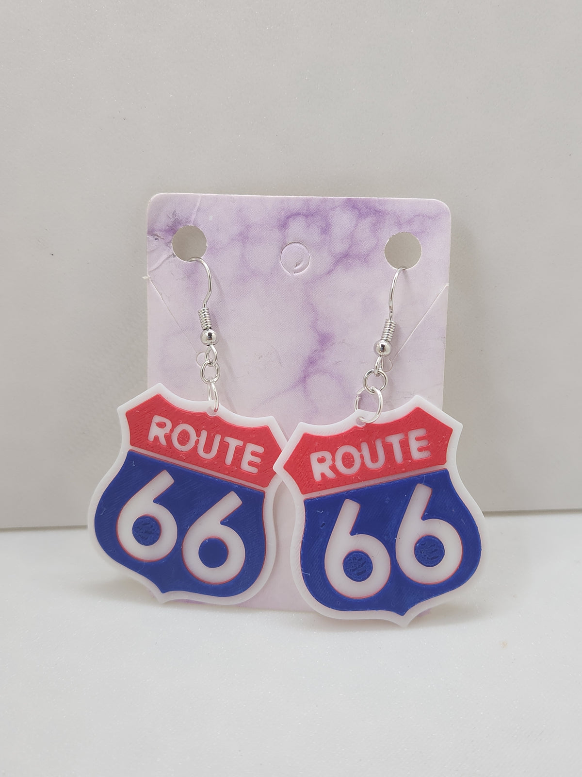 3D printed Route 66 shield earrings in red, white, and blue on silver hooks.