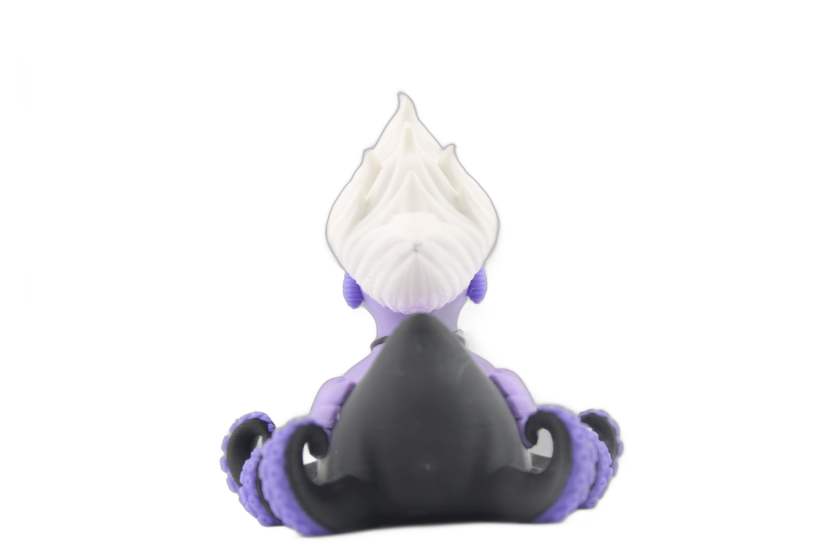 Back view of the 3D printed Ursula duck with white hair, black tentacle body and purple sucker details on a white background