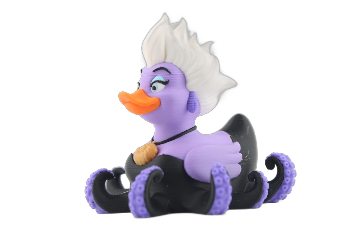Side profile of the 3D printed sea witch duck figurine with white swept hair, orange bill, gold shell necklace and black tentacles